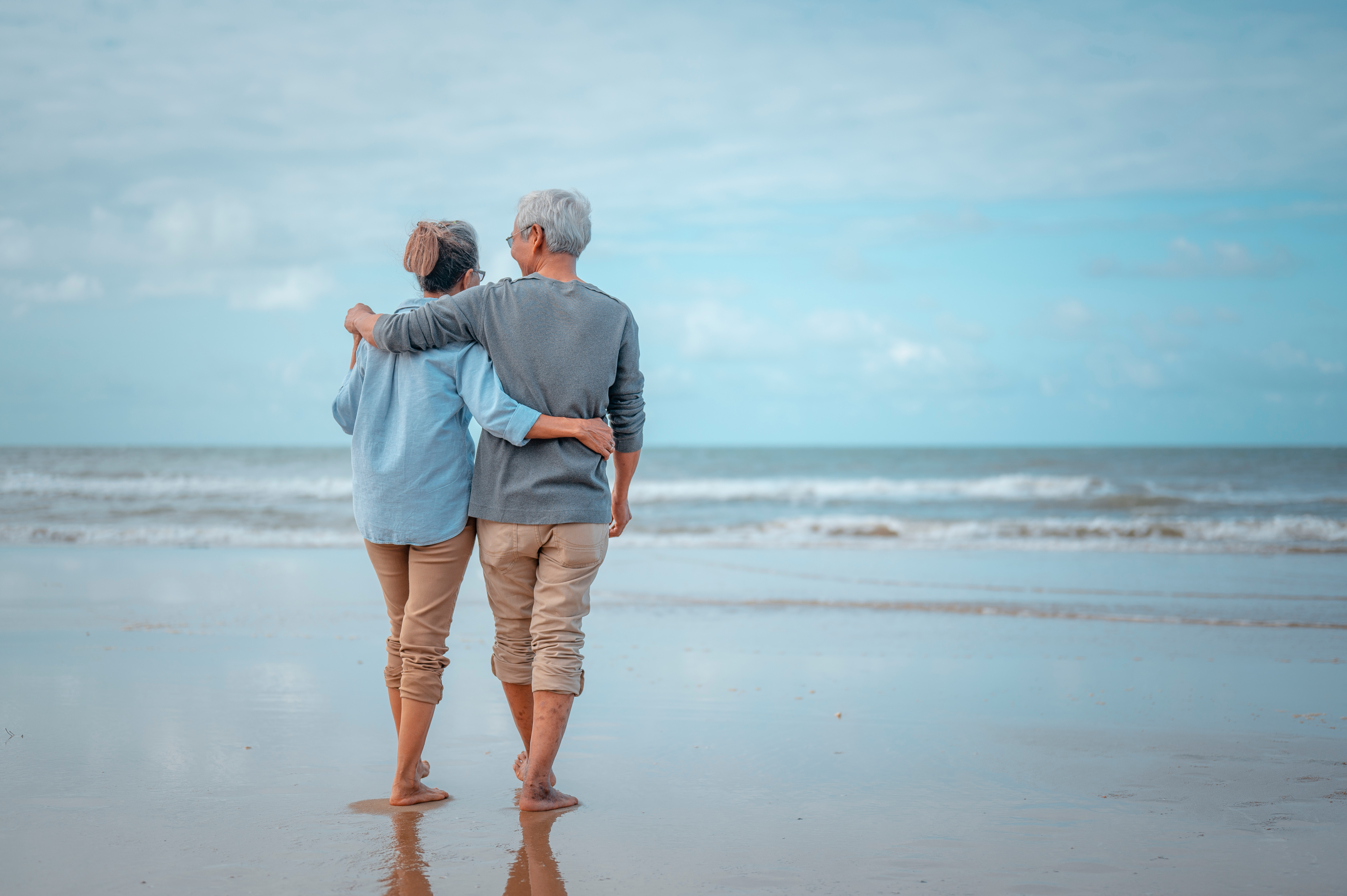 Retired couple walking on the beach